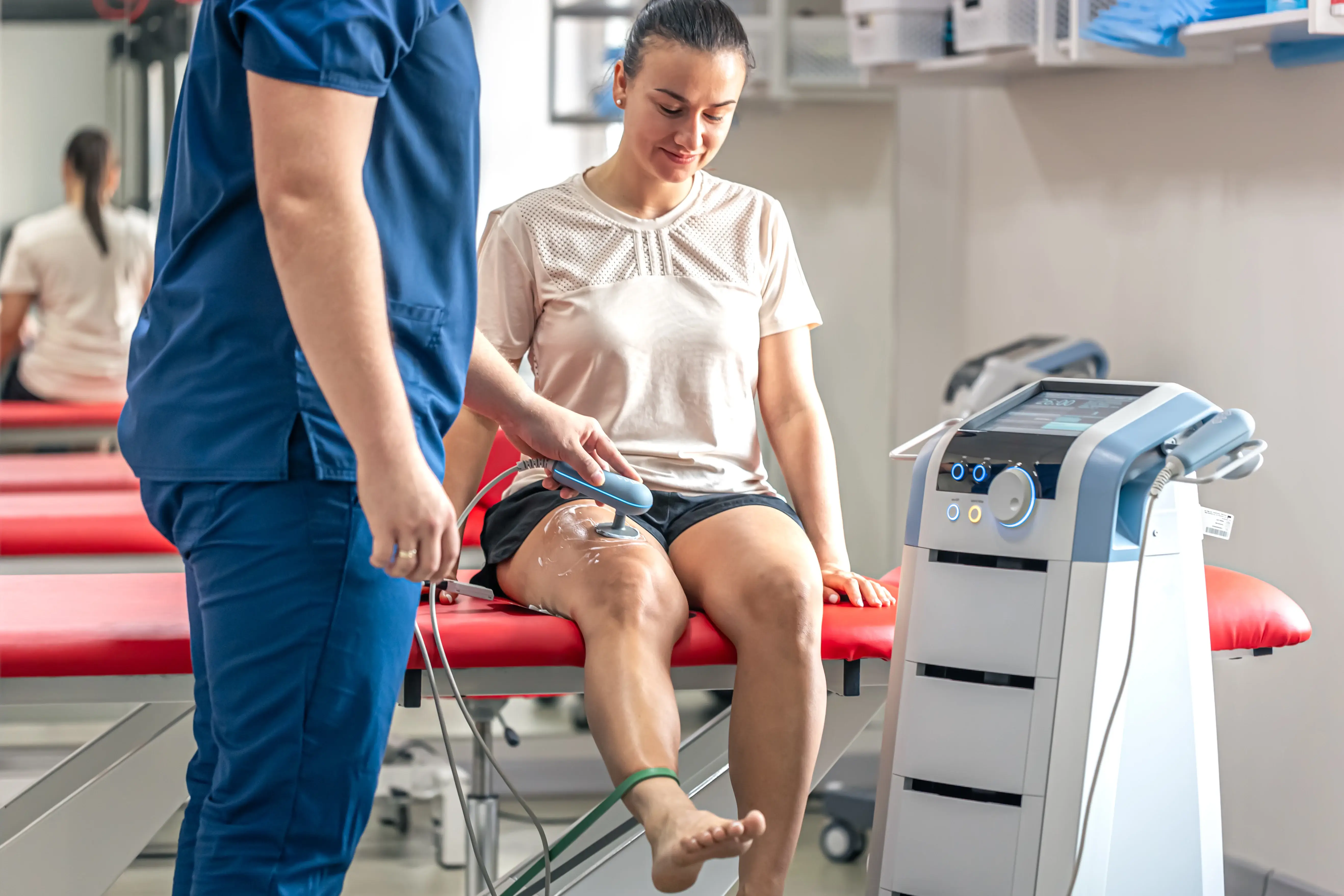 Doctor using advanced equipment to treat knee joints of patient